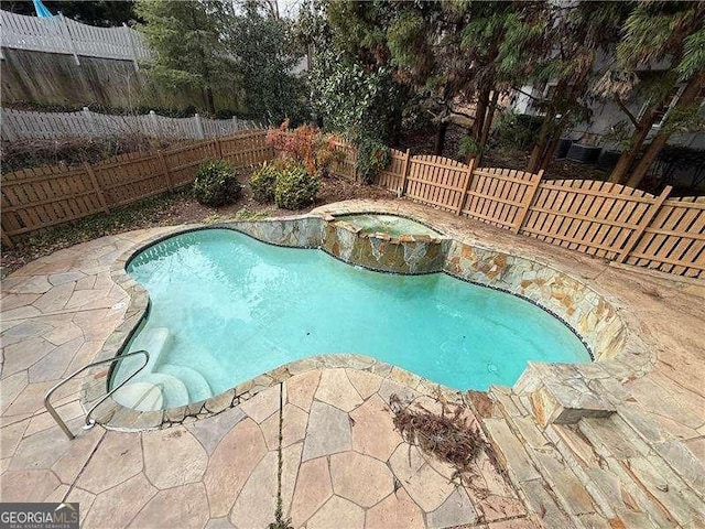 view of pool featuring an in ground hot tub and a patio