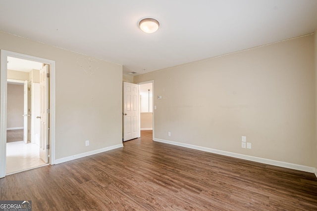 empty room featuring wood finished floors and baseboards