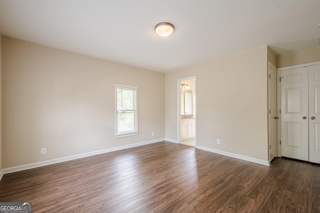 unfurnished room with baseboards and dark wood finished floors