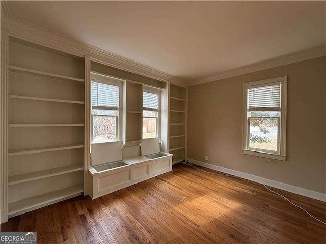 interior space featuring crown molding, hardwood / wood-style floors, and built in shelves