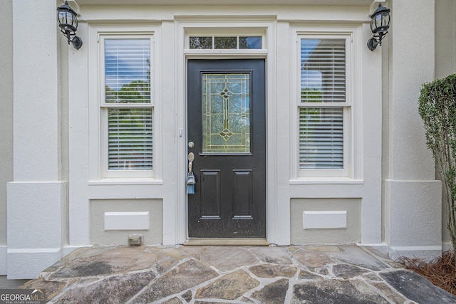 doorway to property featuring stucco siding