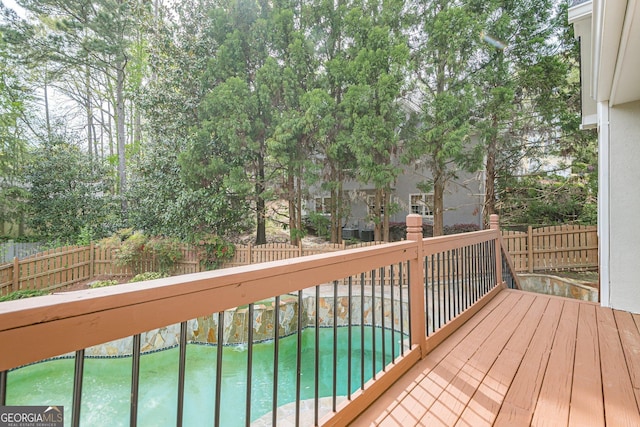 wooden deck with a fenced backyard and a fenced in pool