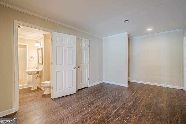unfurnished bedroom featuring baseboards, ornamental molding, dark wood finished floors, recessed lighting, and ensuite bath