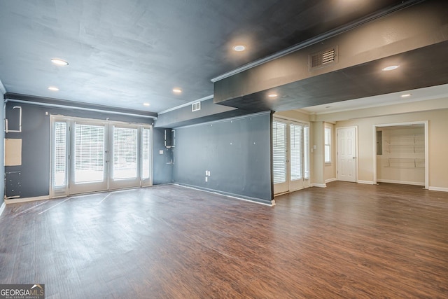 unfurnished living room featuring visible vents, baseboards, and wood finished floors