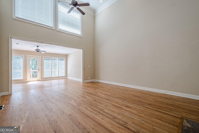 unfurnished living room featuring light wood-style floors, baseboards, crown molding, and ceiling fan