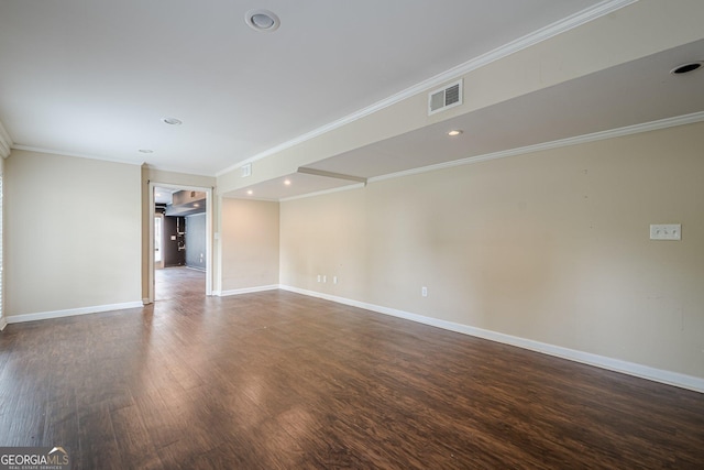 spare room with visible vents, baseboards, crown molding, and dark wood-style floors