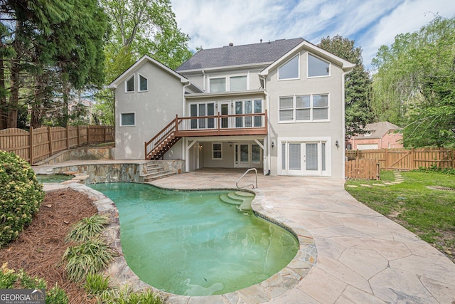 rear view of house with french doors, a patio area, stucco siding, and stairs