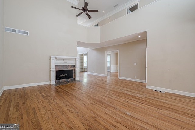 unfurnished living room with visible vents, baseboards, a ceiling fan, and light wood finished floors