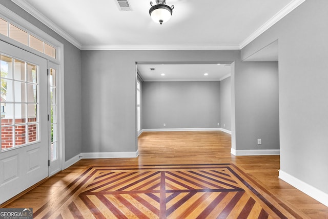 entrance foyer with crown molding, wood finished floors, visible vents, and baseboards