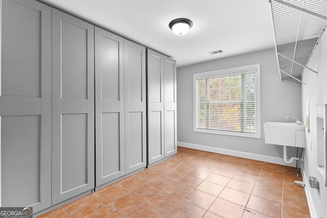 interior space featuring light tile patterned floors, visible vents, and baseboards