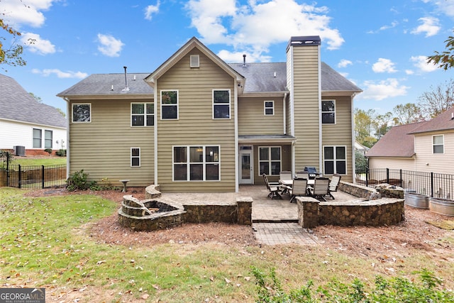 back of house featuring a yard, a chimney, fence, and a patio