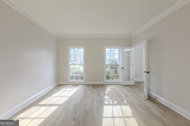 empty room with ornamental molding and light wood-type flooring