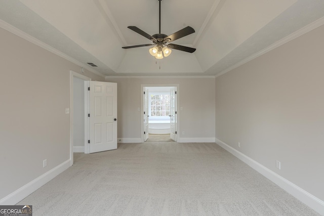 spare room with light carpet, crown molding, a raised ceiling, and ceiling fan