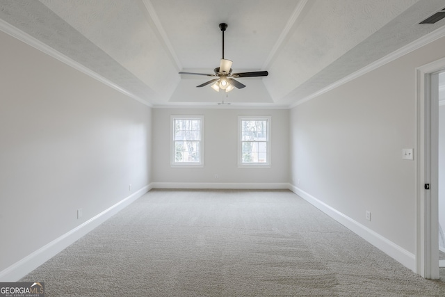 carpeted spare room with ornamental molding, a raised ceiling, and ceiling fan