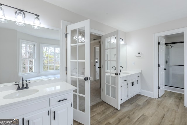 bathroom with vanity, hardwood / wood-style flooring, and french doors