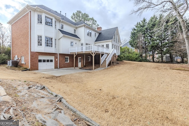 back of property featuring a wooden deck, a garage, a patio area, and central AC unit