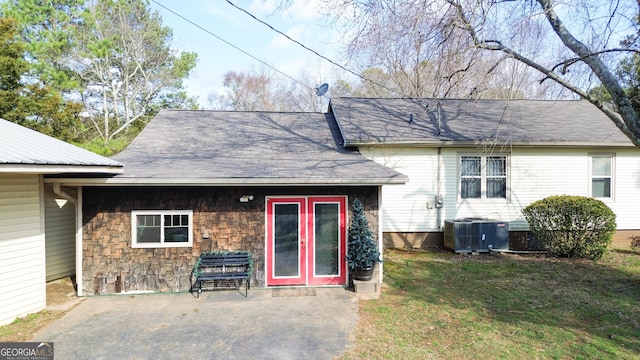 rear view of house with a yard, central AC unit, and a patio area