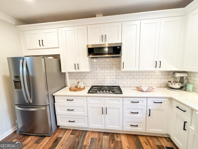 kitchen featuring decorative backsplash, stainless steel appliances, dark hardwood / wood-style floors, and white cabinets