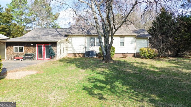 rear view of house with a patio area, central air condition unit, and a lawn