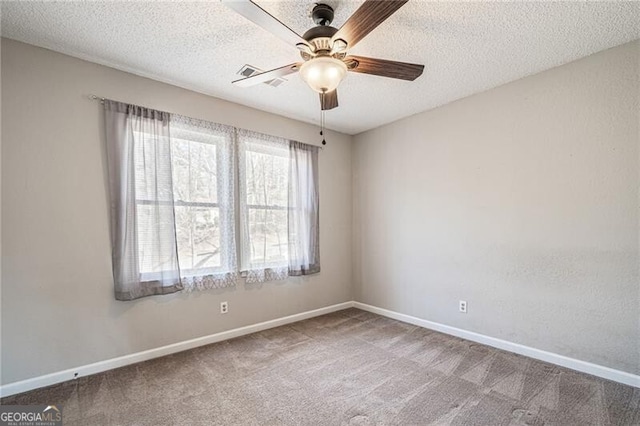 spare room with ceiling fan, carpet, and a textured ceiling