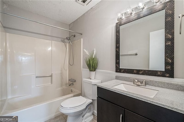 full bathroom with tile patterned floors, toilet, a textured ceiling, shower / washtub combination, and vanity