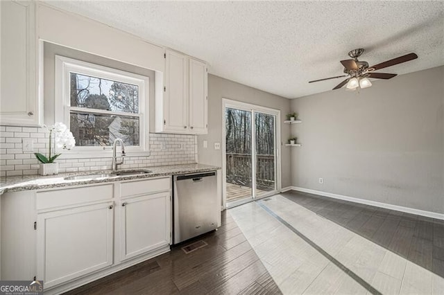 kitchen with white cabinetry, dishwasher, sink, and a wealth of natural light