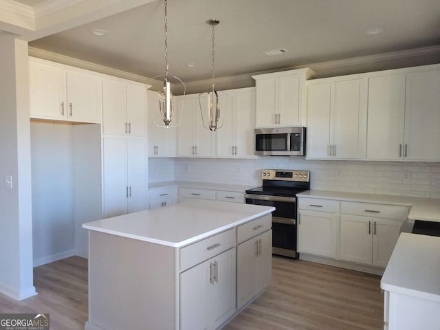 kitchen with decorative light fixtures, a center island, white cabinets, stainless steel appliances, and backsplash