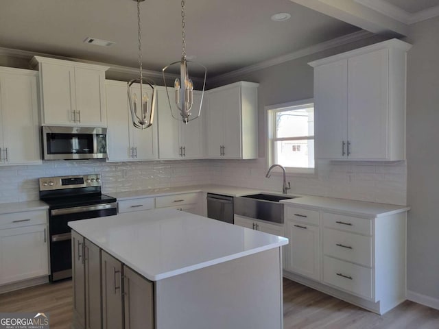 kitchen with sink, stainless steel appliances, white cabinets, and a kitchen island