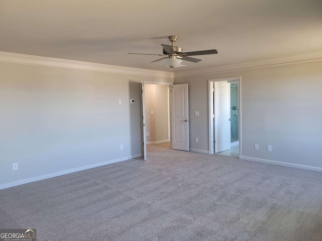 carpeted spare room with ceiling fan and ornamental molding