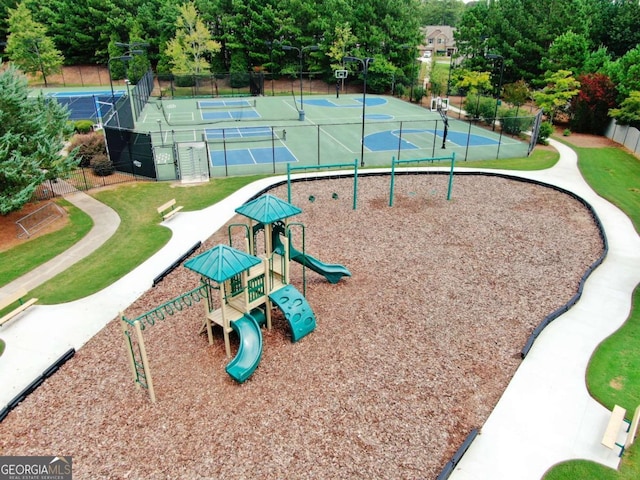 view of community featuring a playground, tennis court, basketball hoop, and a lawn