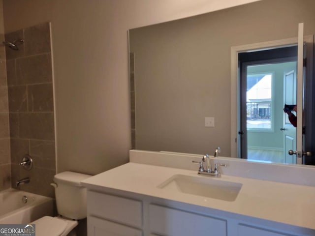 full bathroom featuring vanity, tiled shower / bath combo, and toilet