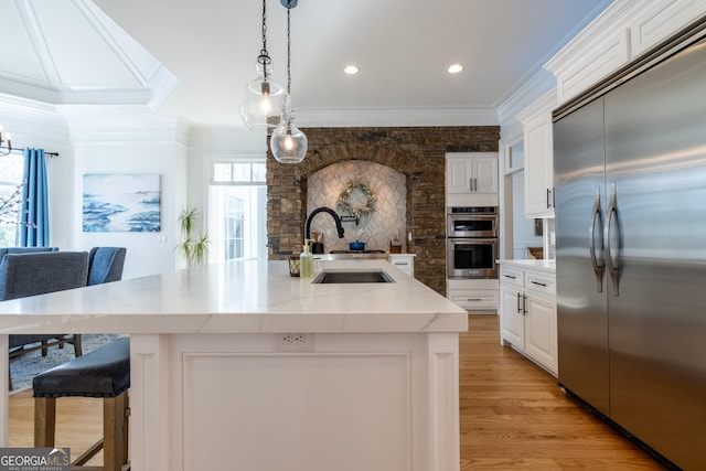 kitchen with a large island, sink, white cabinets, and appliances with stainless steel finishes