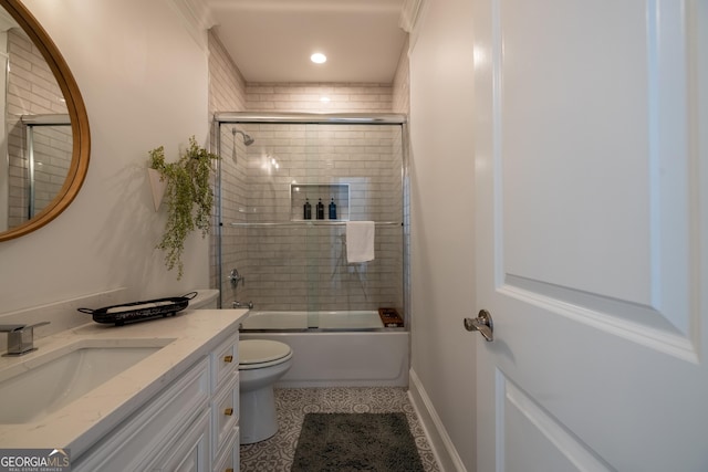 full bathroom featuring vanity, bath / shower combo with glass door, and toilet