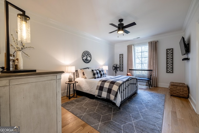 bedroom featuring ornamental molding, dark hardwood / wood-style floors, and ceiling fan