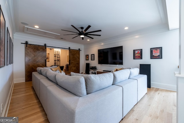 living room featuring crown molding, a barn door, ceiling fan, and light hardwood / wood-style flooring