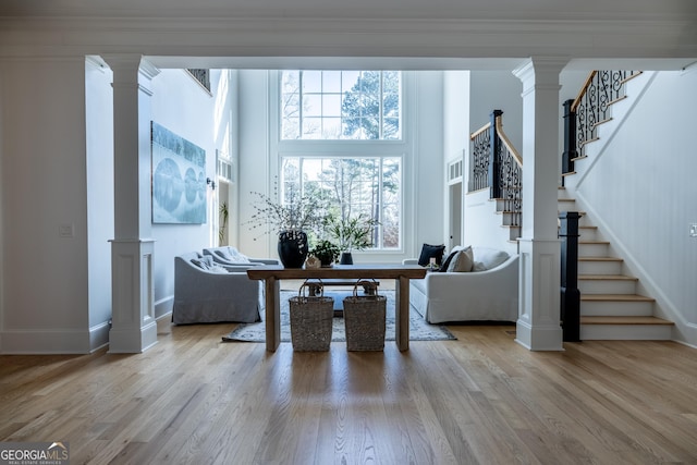 living room featuring decorative columns and light wood-type flooring