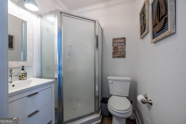 bathroom featuring ornamental molding, a shower with shower door, vanity, and toilet