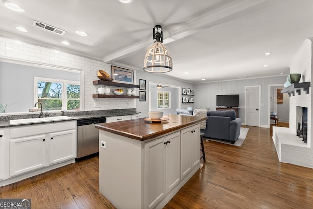 kitchen featuring a center island, sink, stainless steel dishwasher, and white cabinets