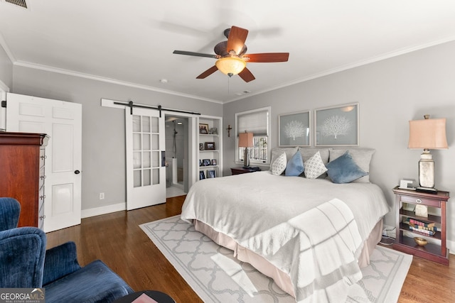 bedroom featuring crown molding, a barn door, hardwood / wood-style floors, and ceiling fan