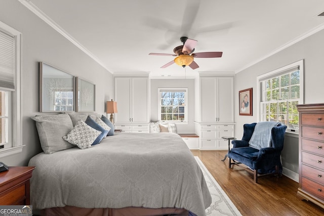 bedroom featuring crown molding, ceiling fan, multiple windows, and hardwood / wood-style flooring