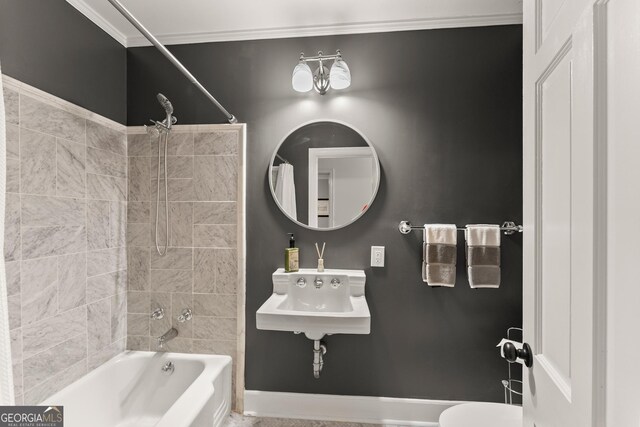 full bathroom featuring tiled shower / bath combo, crown molding, sink, and toilet