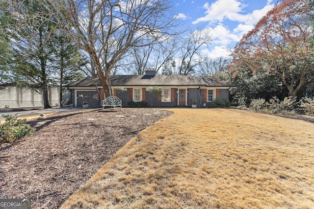 ranch-style house featuring a garage and a front yard