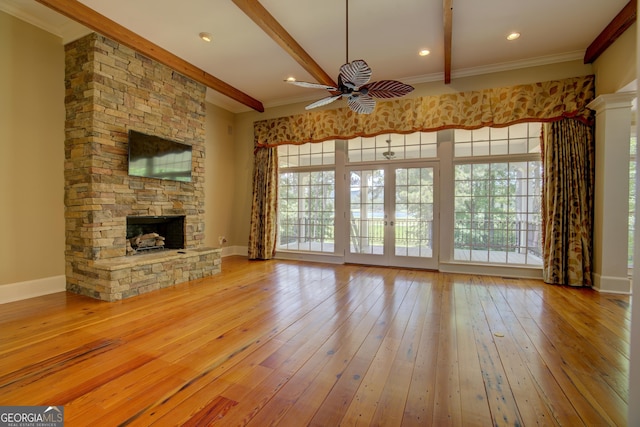 unfurnished living room featuring beamed ceiling, ceiling fan, light wood-type flooring, and a fireplace