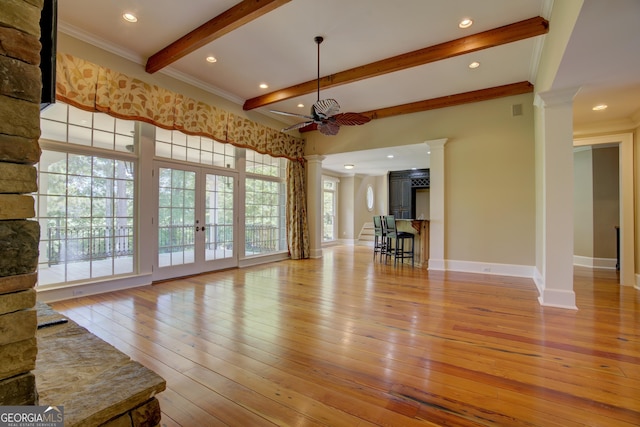 unfurnished living room featuring beam ceiling, ornamental molding, decorative columns, and light hardwood / wood-style floors