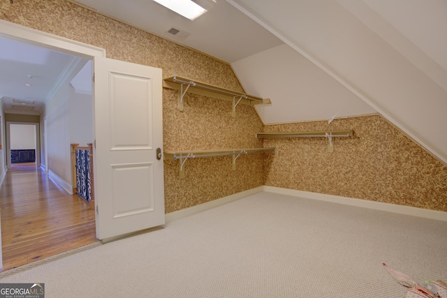 walk in closet with vaulted ceiling and carpet