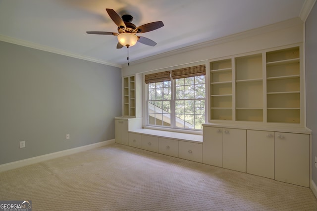 empty room featuring crown molding, light colored carpet, and ceiling fan