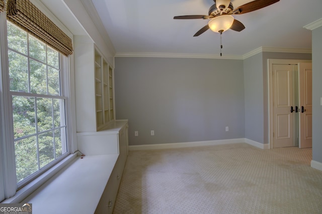 unfurnished room with crown molding, light colored carpet, and ceiling fan