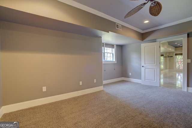 basement featuring carpet floors, ornamental molding, and ceiling fan