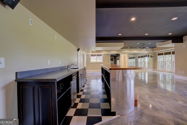 kitchen with beamed ceiling, a healthy amount of sunlight, dishwasher, and sink