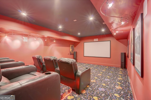 cinema room featuring rail lighting and carpet